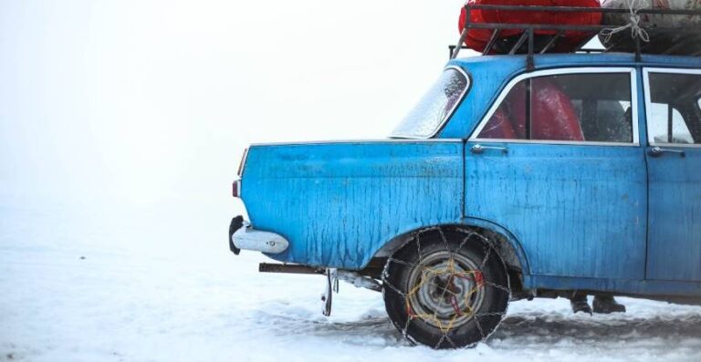 Modré auto se sněhovými řetězy
